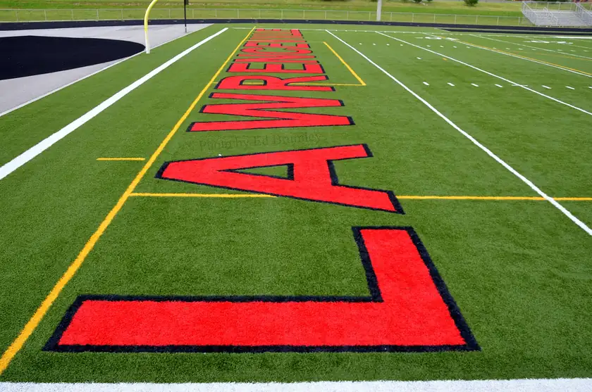 An empty football end zone with the word Gators painted on the turf