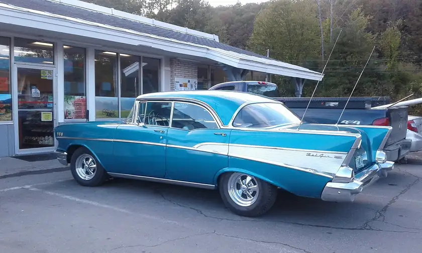 A red 1957 Chevrolet Bel Air parked at a Sunoco station in Putney, Vermont