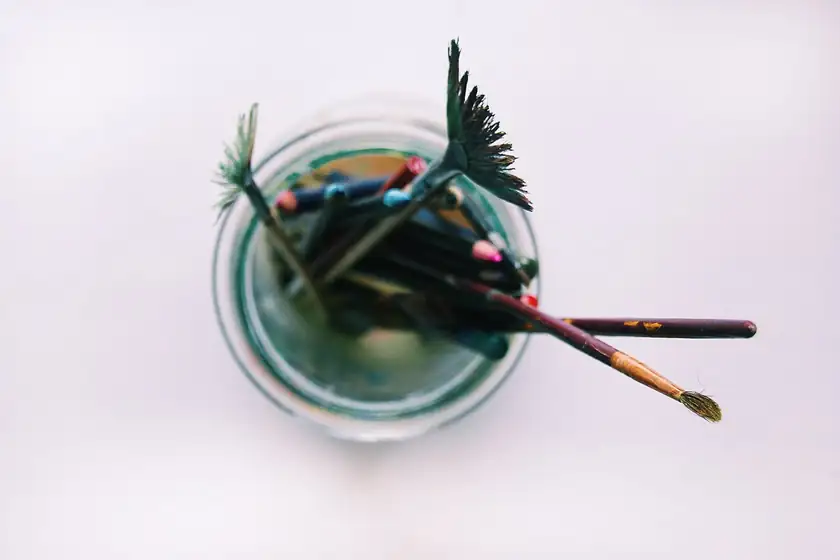 Paintbrushes standing upright in a glass jar