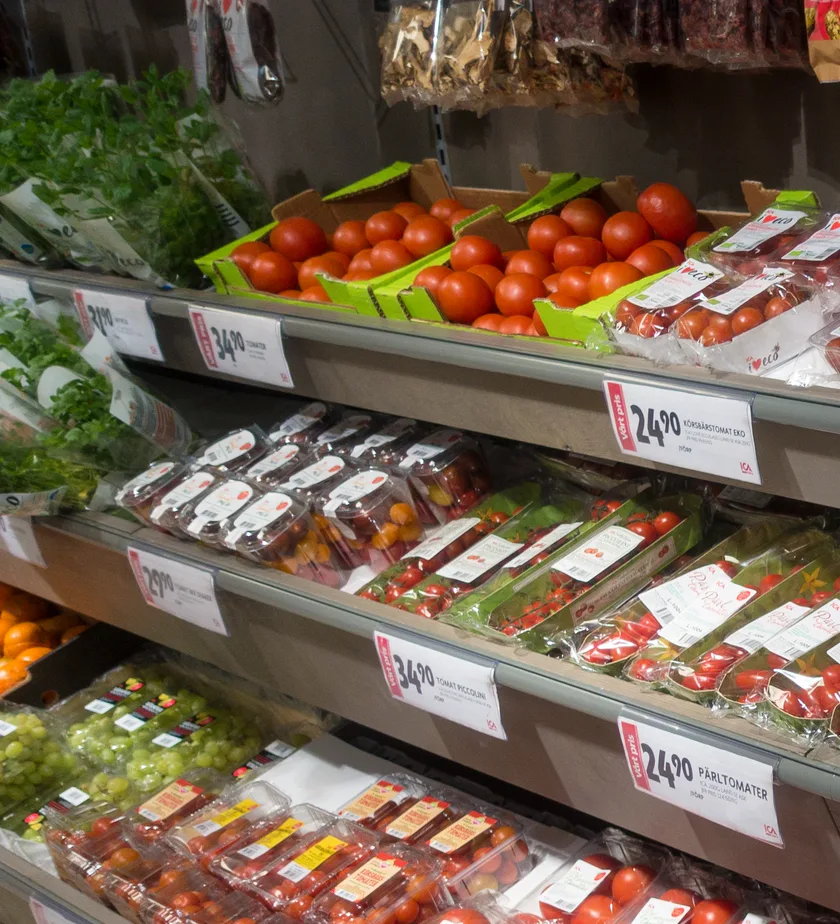 Bins of red and yellow apples beside oranges at a produce stall