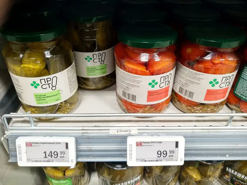 Cans of vegetables lined up on a grocery shelf