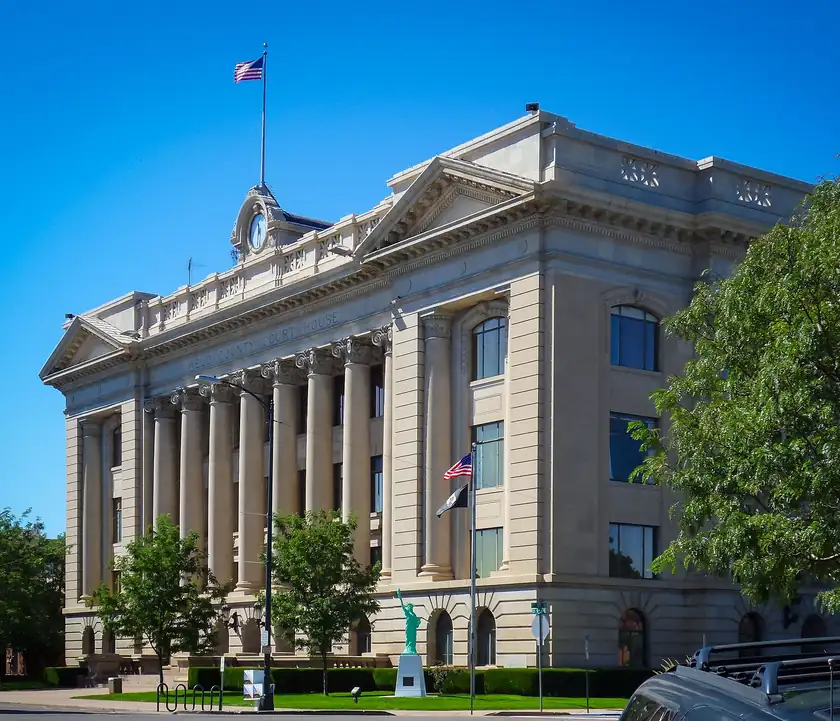 The Weld County courthouse in Greeley, a stone building with a tower and no people close to the camera