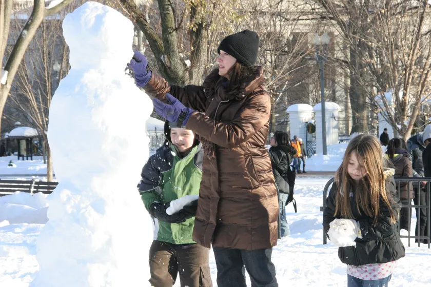 Children in bright winter coats playing in the snow