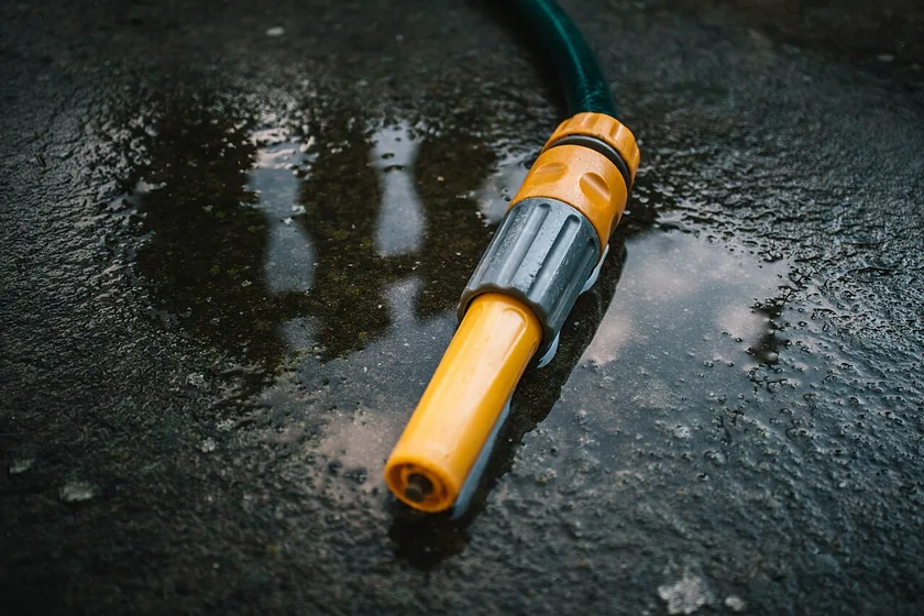 A black garden-hose nozzle with a brass fitting