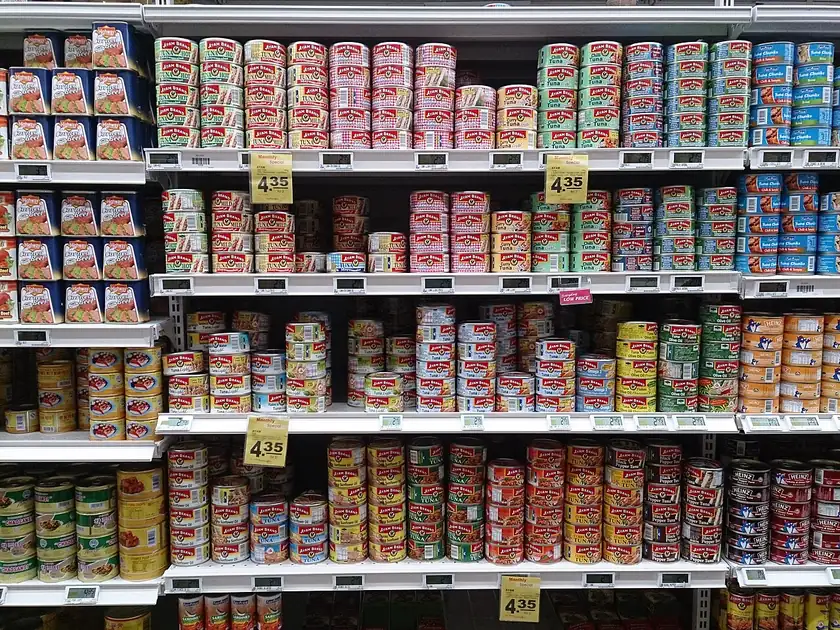 Several open cans of food arranged on a white surface