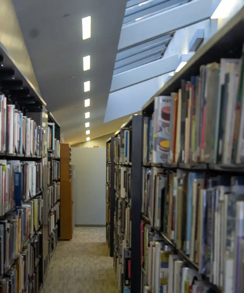 Tall wooden bookshelves filled with books in a library archive