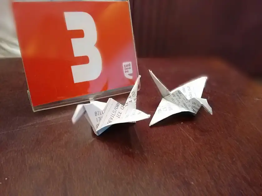 A white origami crane on a dark surface